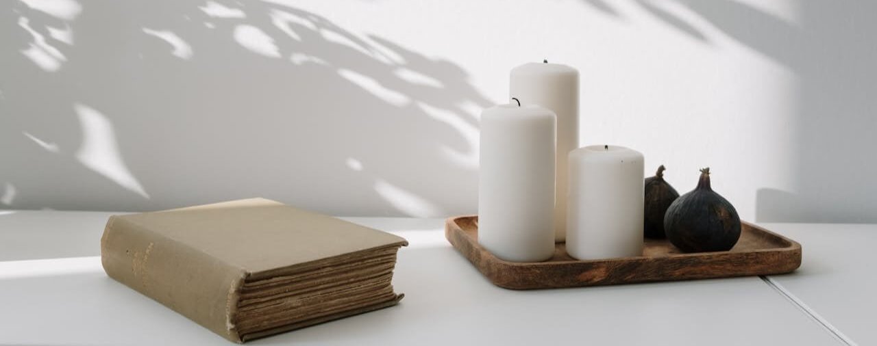 Livre ancien et bougies dans une lumière douce, illustrant la réinvention professionnelle et la cohérence intérieure