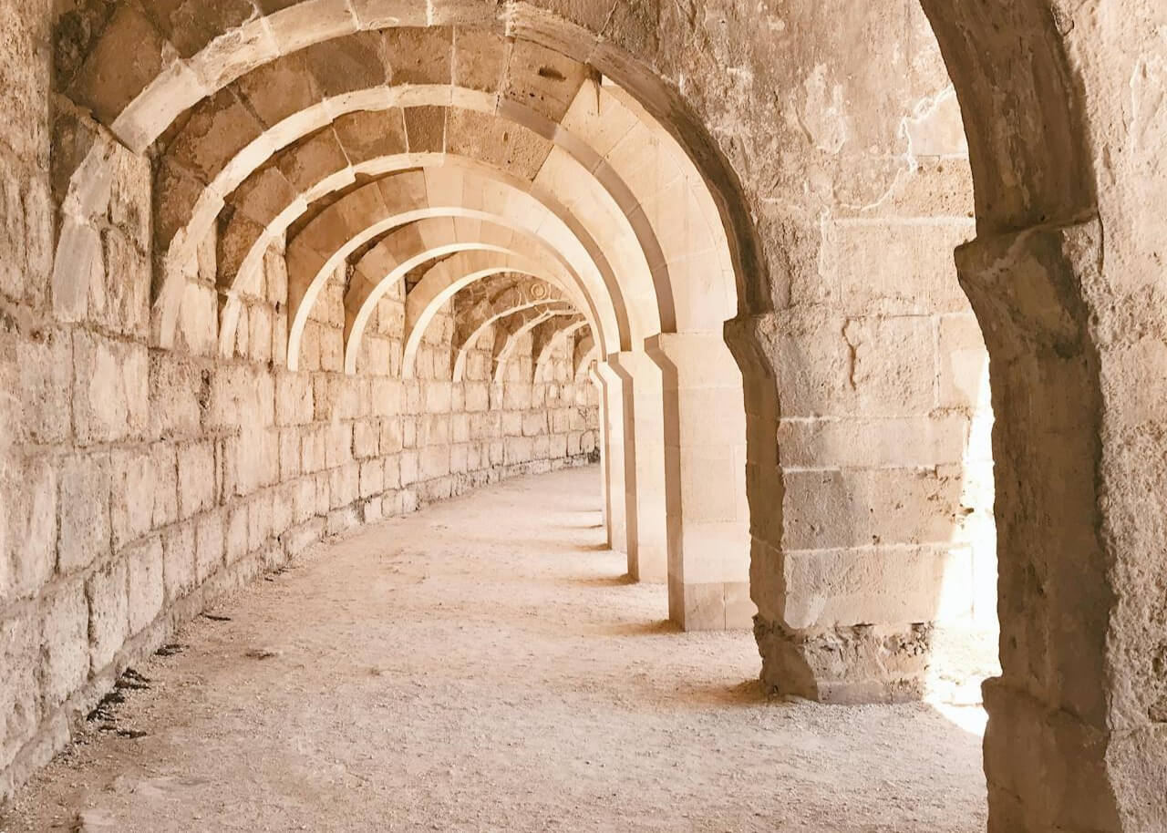 Passage voûté en pierre symbolisant une réinvention professionnelle et un passage intérieur